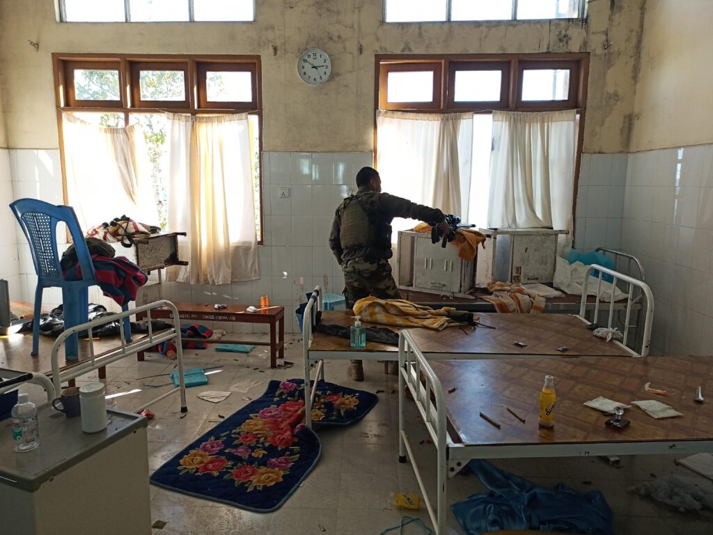A sniper looking from the window of Falam hospital during the middle portion of the battle, his sniper rifle positioned near him.